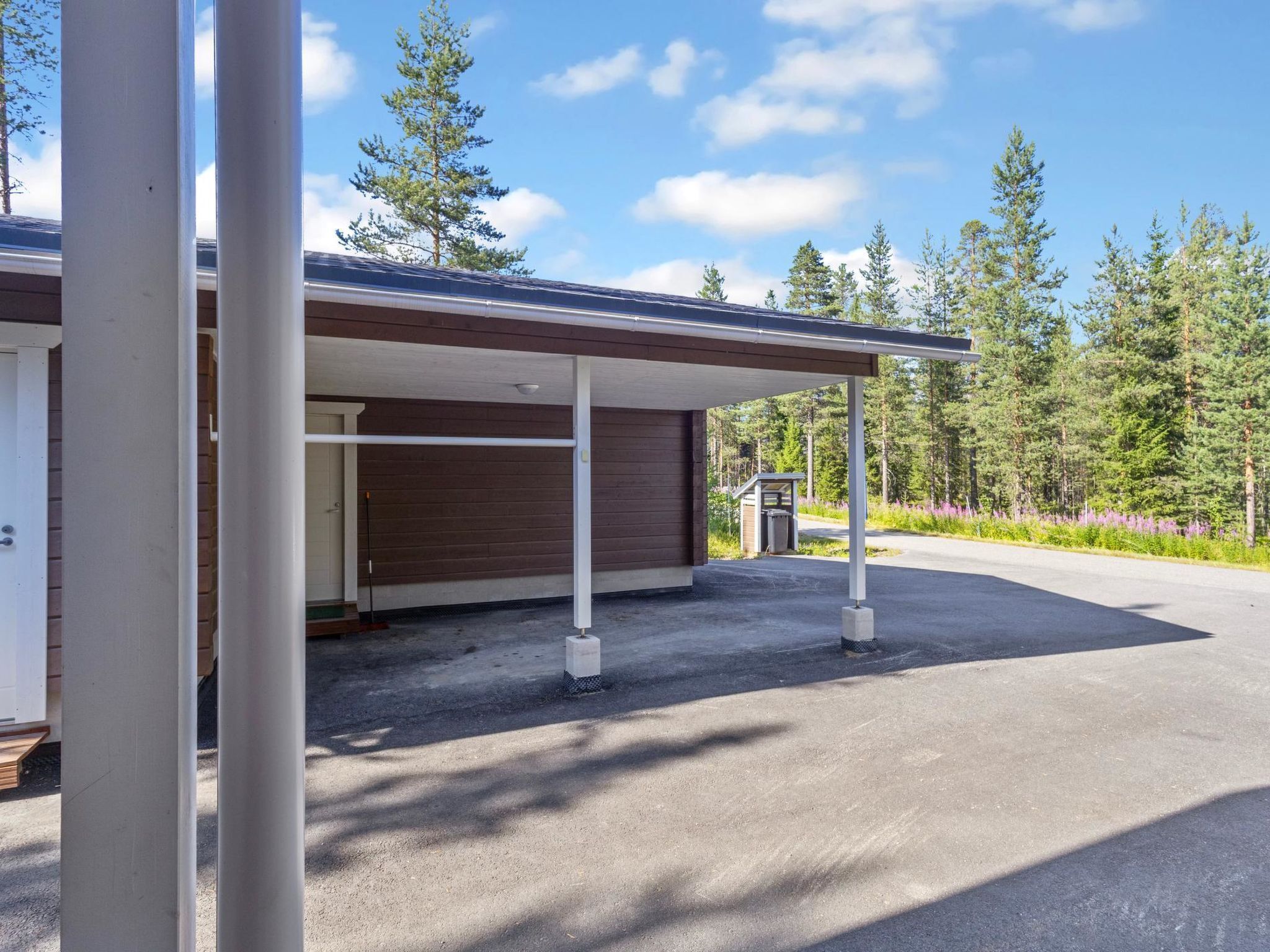 Un bâtiment moderne doté d’une entrée abritée et d’une allée gravillonnée.