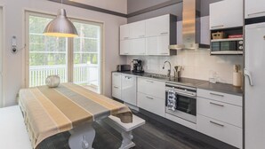 Een moderne keuken met witte kastjes, een roestvrijstalen afzuigkap en een ingebouwde magnetron.