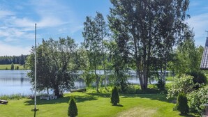 Un espace verdoyant avec un lac, des arbres et un banc.