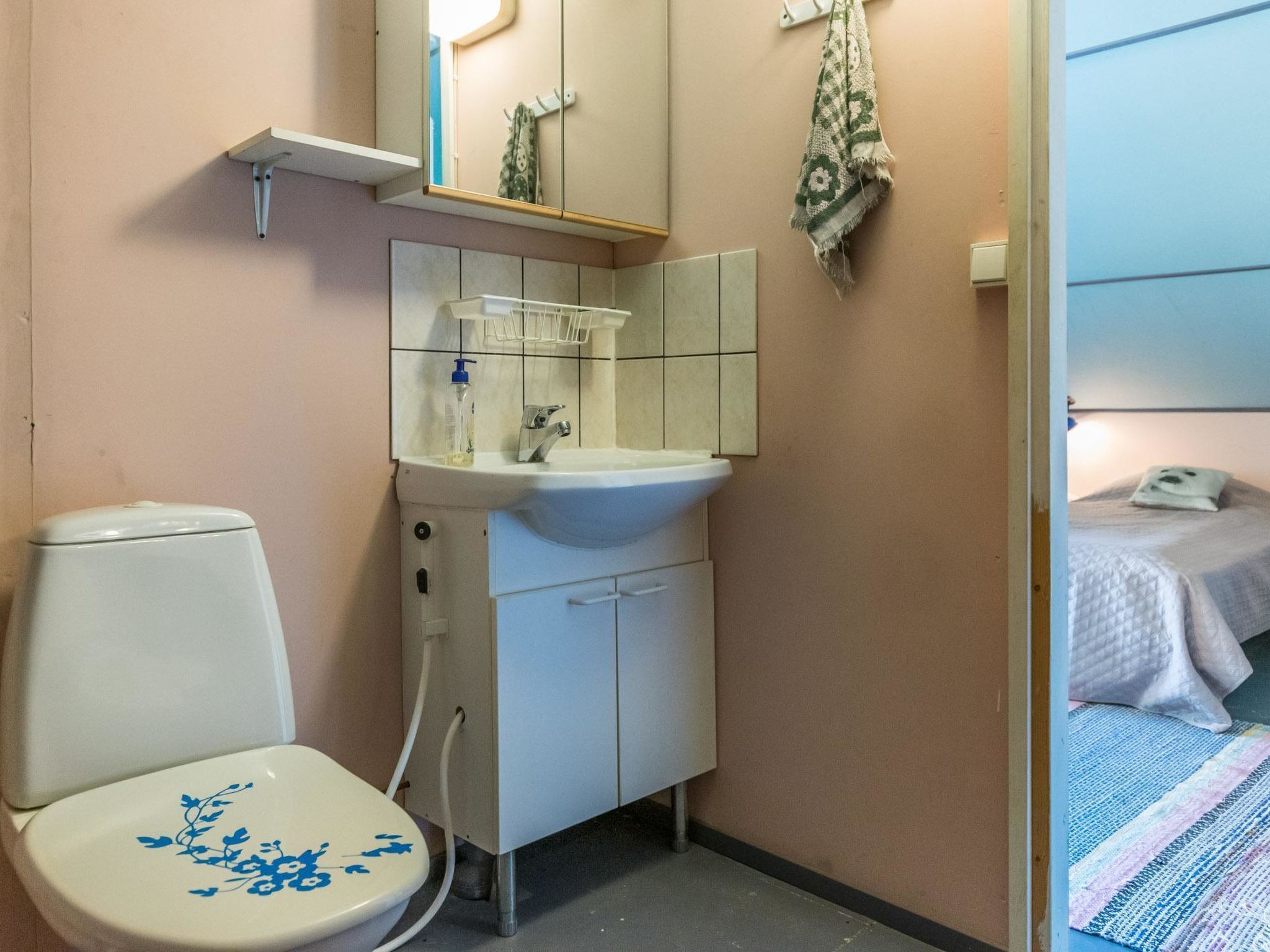 Une salle de bain avec des toilettes, un lavabo et un miroir.
