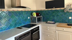 A modern kitchen with a dishwasher, oven, and a microwave on a countertop.