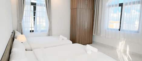 Ein geräumiges Schlafzimmer mit einem großen Bett, einem Holzschrank und Blick aus dem Fenster.