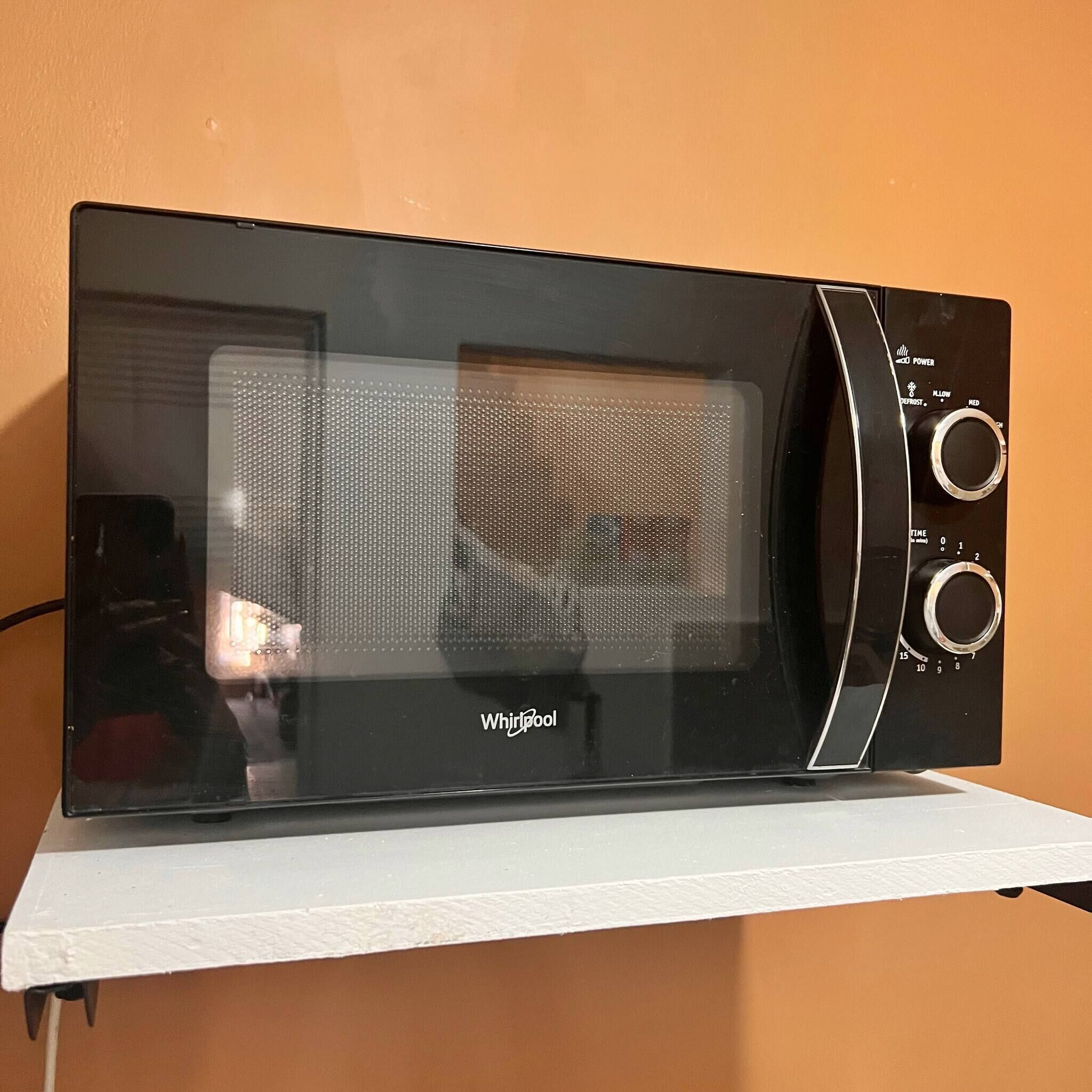 A Whirlpool microwave oven with a digital display and control knobs.