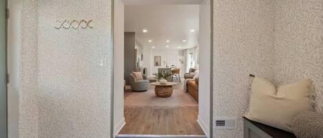 A modern living room with a wooden floor, a round coffee table, and a sofa.
