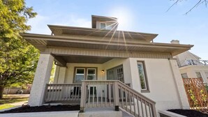 A two-story house with a front porch, a staircase, and a small garden area. - Close to OSU Rooftop Patio  Grill & Outdoor TV (Columbus)
