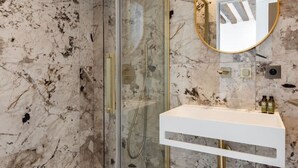 A modern bathroom with a glass shower enclosure, a marble backsplash, and a gold-framed mirror above a white vanity. - 4#New suite 4 personnes- Saint Germain Notre-Dame (Paris)