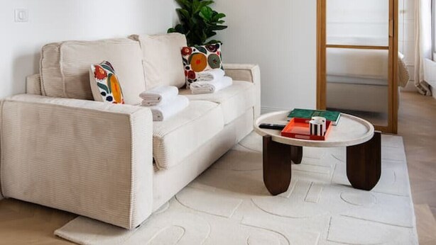 A modern living room with a white sofa, a coffee table, and a wooden ceiling. - 4#New suite 4 personnes- Saint Germain Notre-Dame (Paris)