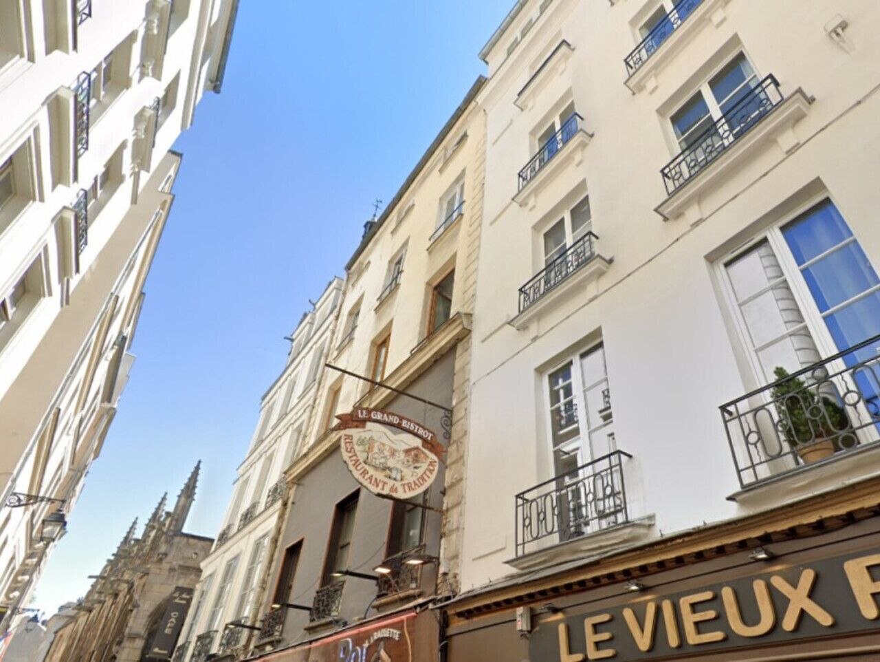 A street view with a restaurant sign for "Le Grand Bistro" and a shop sign for "Le Vieux".