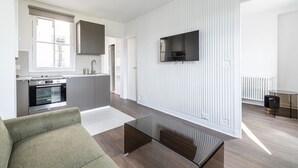 A modern apartment with a kitchen, a dining area, and a living room.