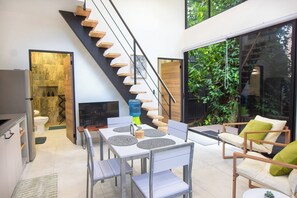 Een modern interieur met een trap, eethoek en terras.