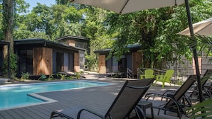 Un espace aménagé au bord de la piscine, avec des chaises longues et une piscine.