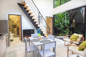 Een modern interieur met een trap, eethoek en terras.