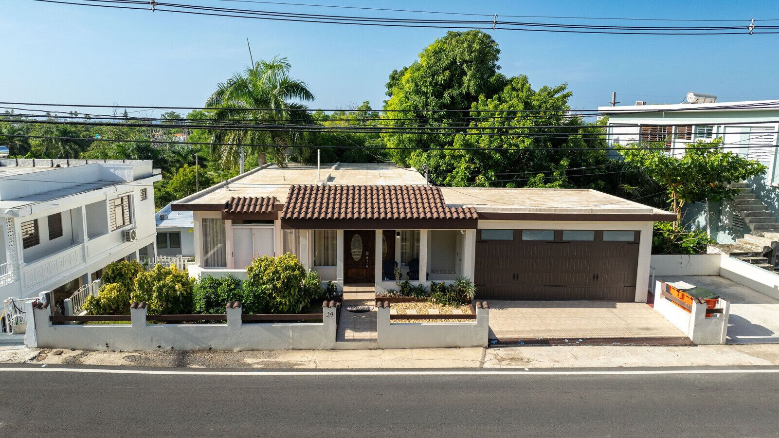 A two-story house with a tiled roof, a front porch, and a garage.