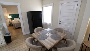 Una cocina compacta con una mesa de comedor, sillas y un refrigerador.