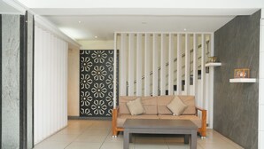 A modern living room with a sofa, a coffee table, and a patterned wall. - Hotel Grand Leela Krishna  (Bhimavaram)