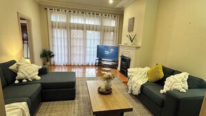A living room with a sofa set, a coffee table, and a TV.