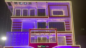 A multi-story hotel with a modern design, featuring a prominent entrance with a neon sign.