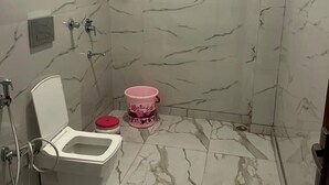 A bathroom with a toilet, a shower, and a sink.