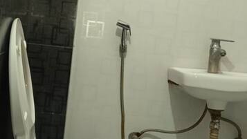 Un baño con inodoro, bidé y lavamanos.
