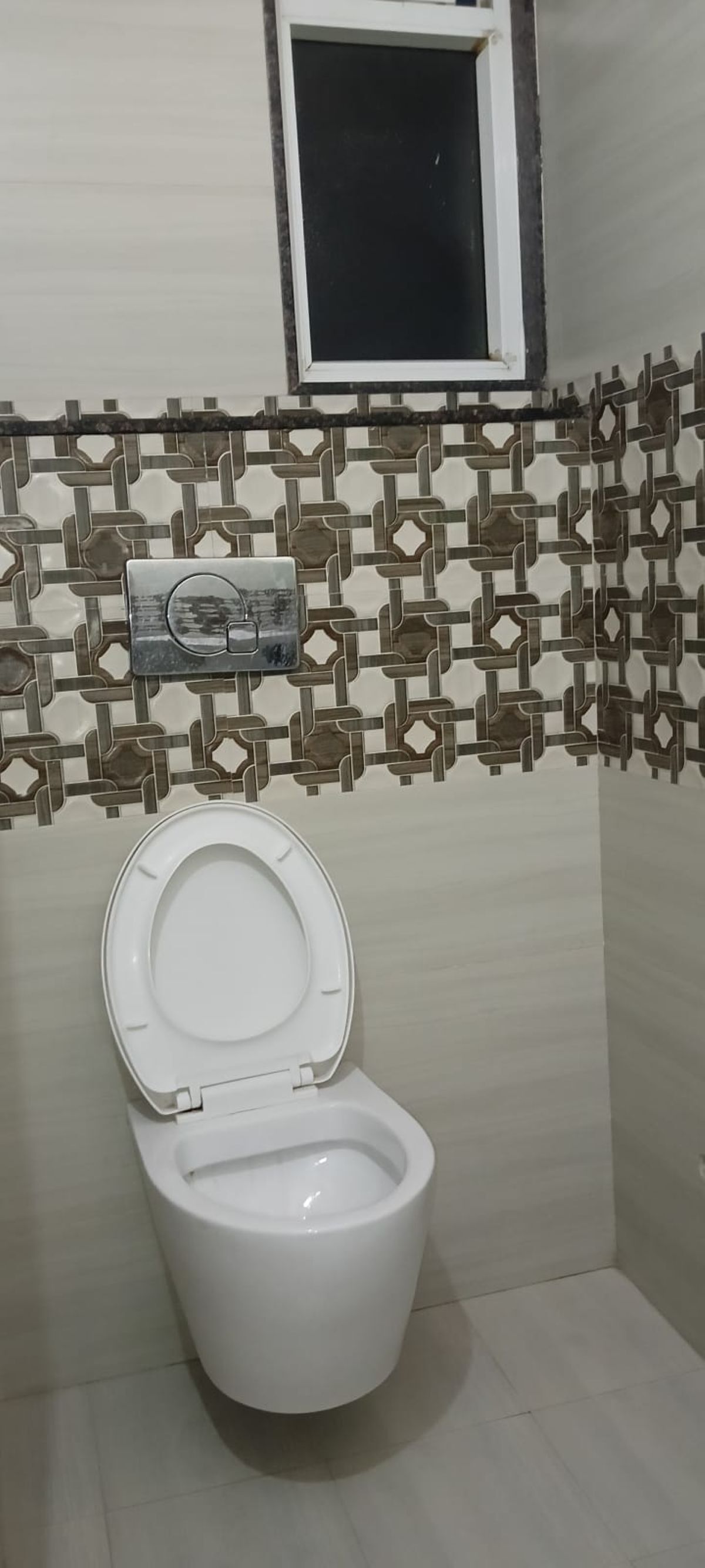 A bathroom with a toilet, a patterned tile backsplash, and a small window above the toilet.
