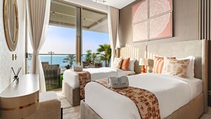 A hotel room with a large bed, a smaller bed, a desk, and a view of the ocean. - FIRST CLASS | 4BR | Elegant Beach House Retreat (Palm)