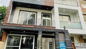 A multi-story building with balconies, large windows, and a sign indicating "OPO MINISTAR M-180". - OPO MINISTAR M180 (Gurugram)