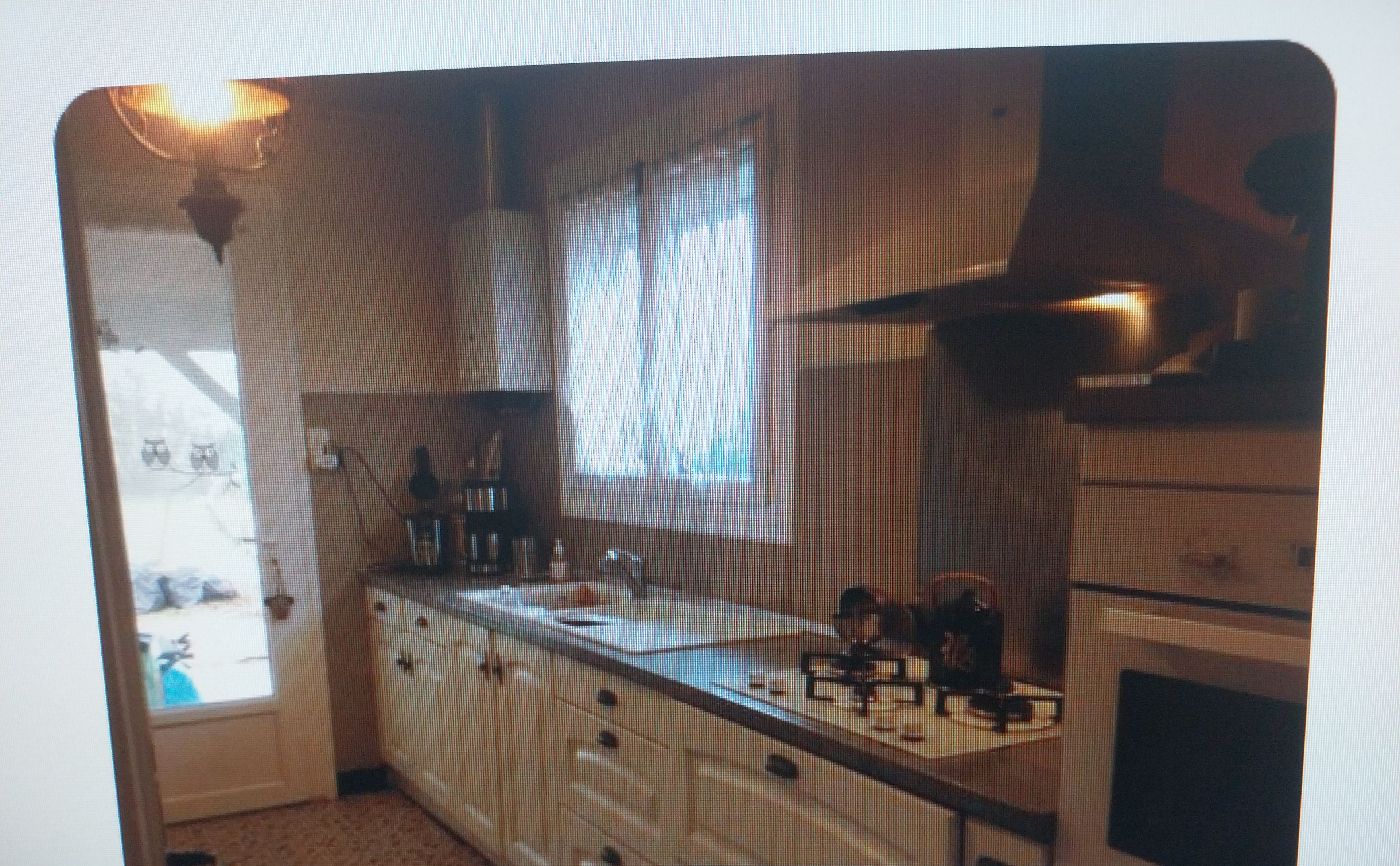 A kitchen with a stove, sink, and cabinets.