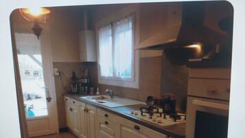 A kitchen with a stove, sink, and cabinets.