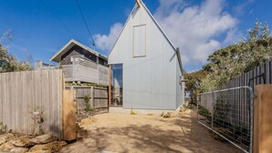 Ein modernes Haus mit großer Garage, Holzlattenzaun und Metalltor.