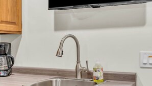 A kitchen with a stainless steel sink, a coffee maker, and a bottle of dish soap. - Stylish Zen Stay Mins to Falls | BBQ Area (Niagara Falls)