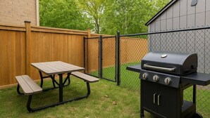 A backyard with a picnic table and a portable grill. - Stylish Zen Stay Mins to Falls | BBQ Area (Niagara Falls)
