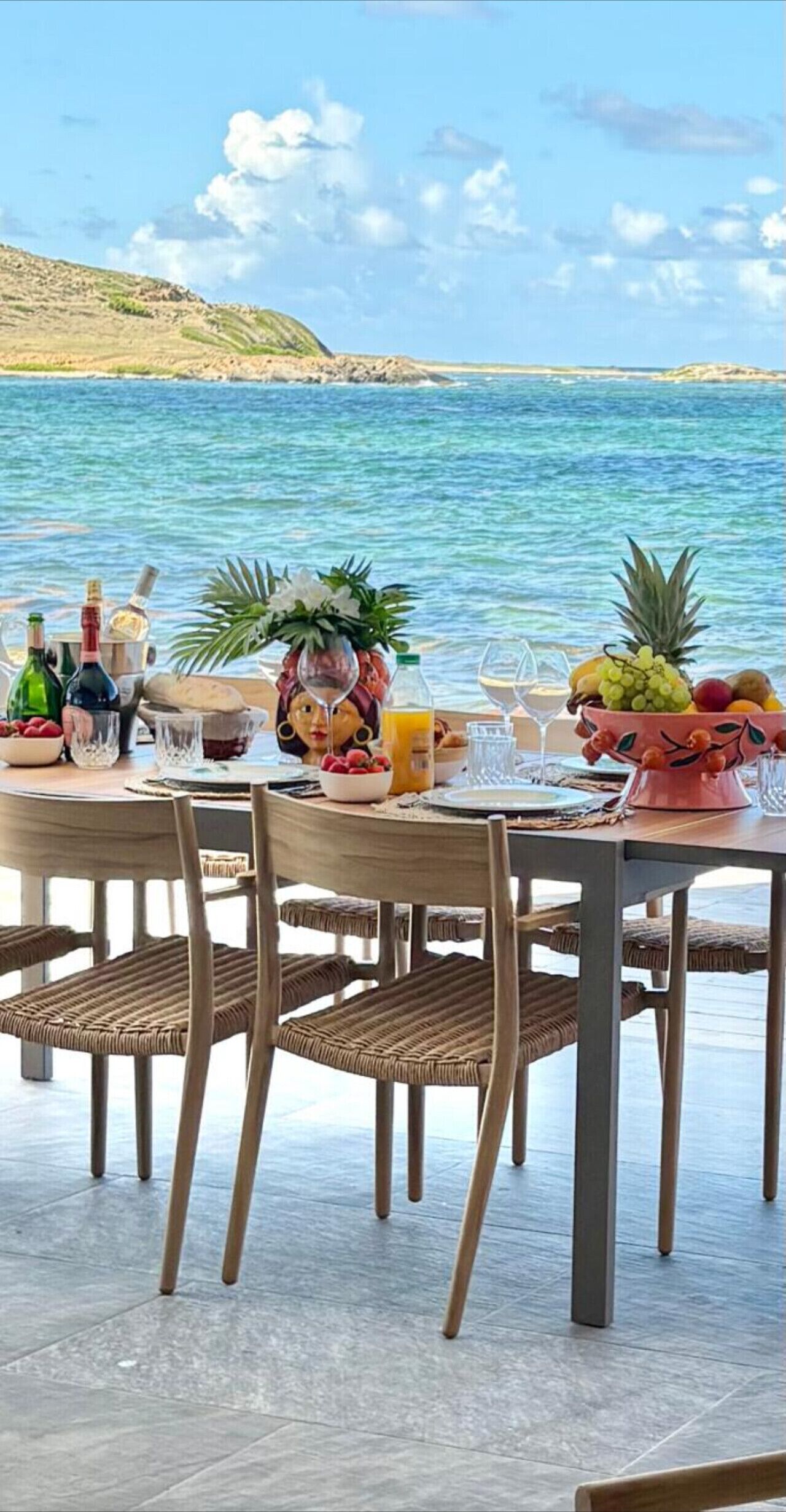 A table set for a meal with a view of the sea.