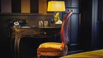 A vintage-style desk with a telephone, a lamp, and decorative items.