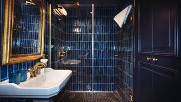 A modern bathroom with a large mirror, a white sink, and a glass shower enclosure.