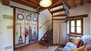 Eine Treppe mit einer Holzhandläufe und einer gewebten Leuchte darüber.