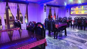 Ein Restaurant mit Glastisch, Stühlen und einem gemusterten Boden.