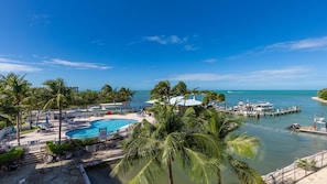 A resort with a swimming pool, palm trees, and a marina with boats. - Unwind in Paradise at The Hammocks at Marathon – 2 Bedroom Escape! (Marathon)