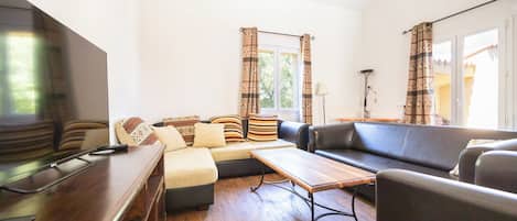 Ein modernes Wohnzimmer mit einer Couch, einem Couchtisch und einem Fernseher.