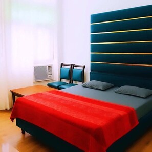 Un dormitorio con una cama, una mesita de noche y una silla.
