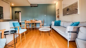 A modern living room with a sofa, chairs, a dining table, and a kitchen area. - Easylife - Contemporary design in Porta Sempione (Milano)