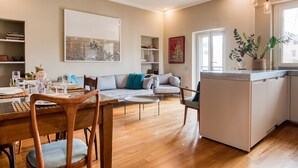 A modern living room with a dining area, a sofa set, a kitchen island, and a large window. - Easylife - Contemporary design in Porta Sempione (Milano)