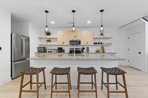 A spacious, modern kitchen with bar seating for four—perfect for sharing meals before heading out to explore nearby breweries and entertainment.