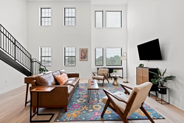 Soaring ceilings and modern design welcome you to Lockwood Loft’s airy living room—ideal for relaxing after exploring walkable North Kansas City.