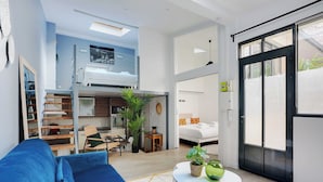 Ein modernes Apartment mit Wohnbereich, Küchenzeile und einem Balkon.