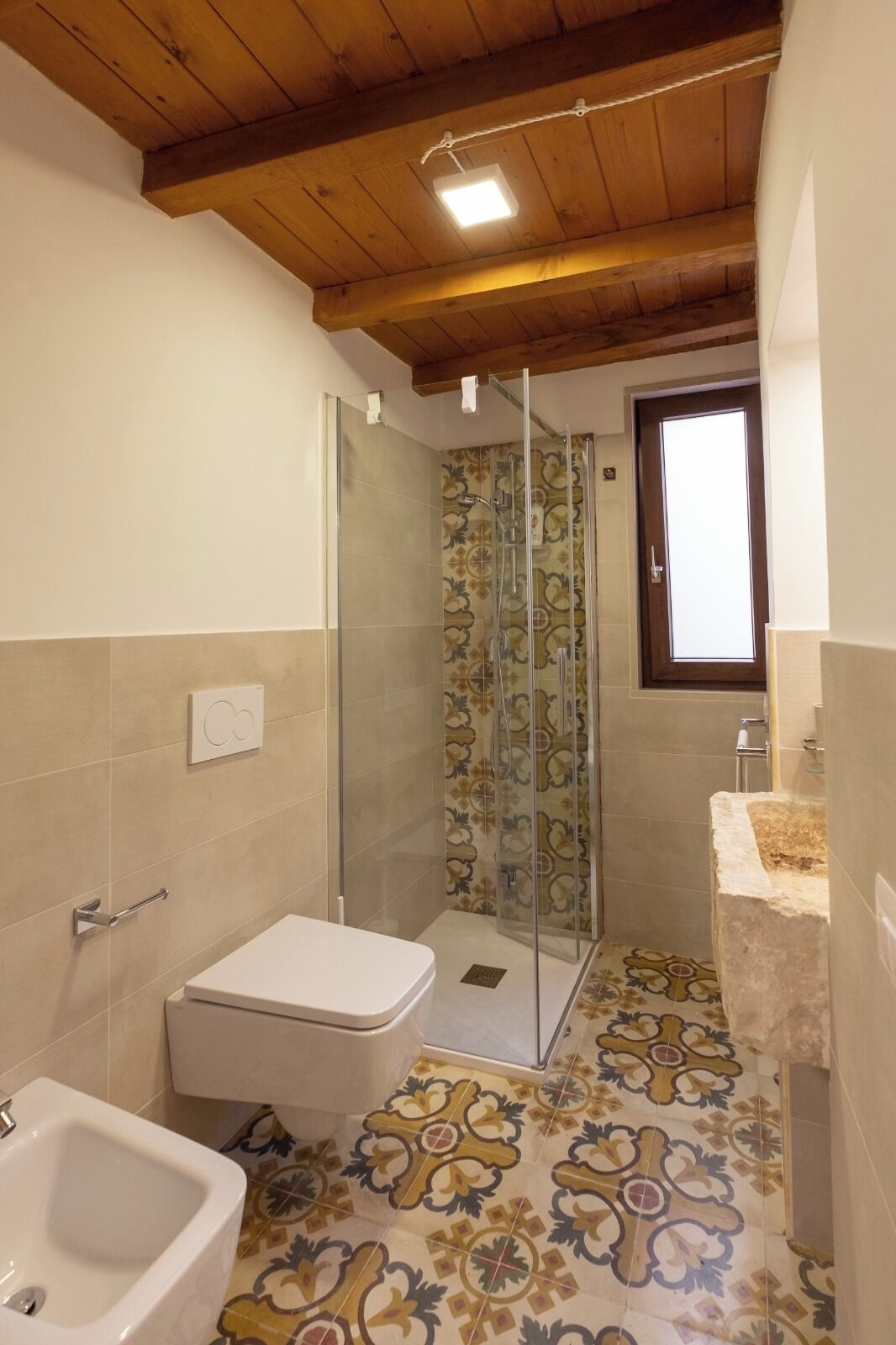 A bathroom with a shower, toilet, and bidet.