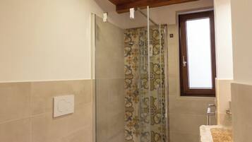 A bathroom with a shower, toilet, and bidet.