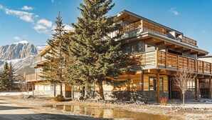 A modern two-story building with a wooden exterior, large windows, and a balcony. - Aurora Lite - Brand new suite with private entrance (Canmore)