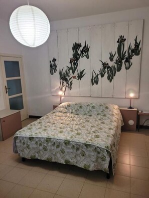 A bedroom with a bed, a wall-mounted light fixture, and a decorative wall panel. - B&B ARCADIA (Casanova Lonati)