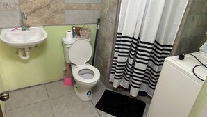 Un bagno con lavandino, toilette e tenda da doccia.