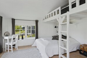 A bedroom with a bunk bed, a desk, and a chair.